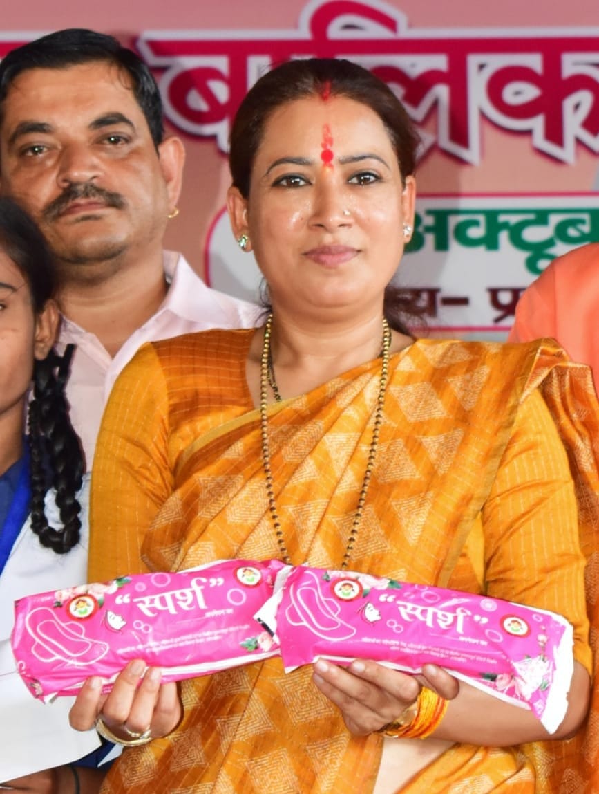 बालिकाओं को निशुल्क स्पर्श सेनेटरी नैपकिन वितरित करती हुई मंत्री